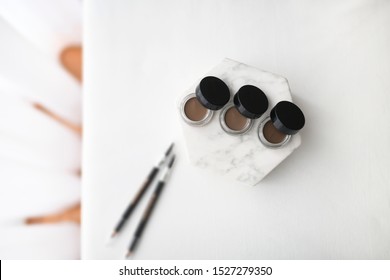 Professional make up product for brows. Gel pomade for eyebrows with black caps. Cosmetic products for make up artist. Plain background.