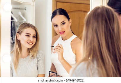 Professional makeup artist to do make up beautiful young model. New look in beauty studio. Cosmetics, brushes and visage 