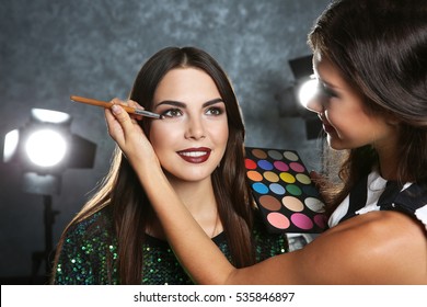 Professional makeup artist working with beautiful young woman - Shutterstock ID 535846897
