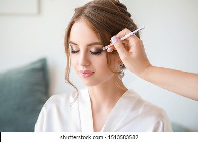 Professional makeup artist working with young bride at home - Powered by Shutterstock