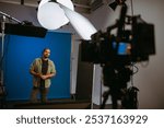 Professional male actor works in the frame on the set. Shooting with a car on a large white cyclorama. Handsome young man on the set of a movie, commercial or TV series. Filming indoors, studio