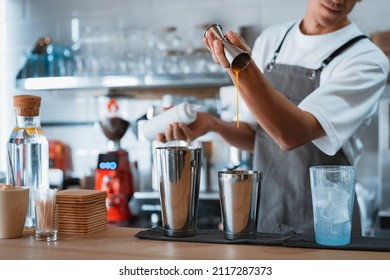 professional male barista making caramel iced frappe while working in local coffee shop - Powered by Shutterstock