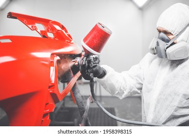 Professional Male Car Painter Is Painting In Garage By Airbrush. Man Works With Spray Gun.