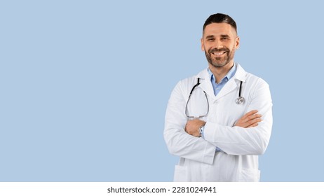 Professional male doctor in white uniform with stethoscope posing crossing hands and smiling, standing over blue background, panorama, free space. Physician and medic profession concept - Powered by Shutterstock