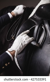 Professional Male Equestrian Rider Saddle Up Horse For Dressage On Training Or Competition - Unrecognizable Closeup, Focus On Hands, Saddle And Stirrup. Concept Of Animal Loving And Having Hobby