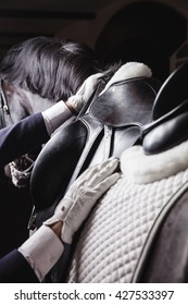 Professional male equestrian rider saddle up horse for dressage on training or competition - Unrecognizable closeup, focus on hands, saddle and mane. Concept of animal loving and having hobby