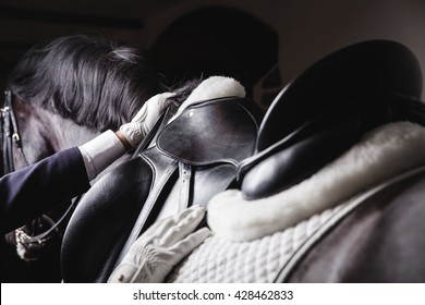 Professional male equestrian rider saddle up horse for dressage on training or competition - Unrecognizable closeup, focus on hands, saddle, reins and mane. Concept of animal loving and having hobby