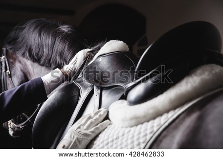 Professional male equestrian rider saddle up horse for dressage on training or competition - Unrecognizable closeup, focus on hands, saddle, reins and mane. Concept of animal loving and having hobby Сток-фото © 