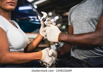 Professional Male And Female Mechanic Checking Hands In The Other Hand He Holds A Wrench In The Garage.