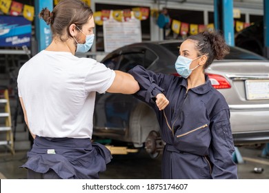 Professional male and female mechanic worker wearing face mask for health and protect coronavirus or PM 2.5 greeting bumping elbows at auto car repair shop. Car repair service and health concept - Powered by Shutterstock