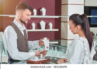 Professional male jeweler helping his female customer at the sto