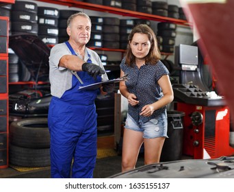 Professional male mechanic discussing with female client and recording list of works on car repair at auto repair shop  - Powered by Shutterstock