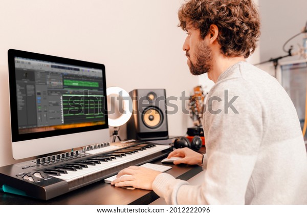 Professional male music\
producer, composer working in recording home studio. Music\
production\
concept.