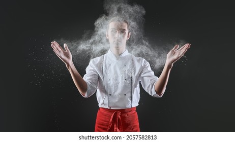 Professional male pastry chef prepares an exquisite dish with flour flying in the air in a restaurant kitchen. Food and meals. - Powered by Shutterstock