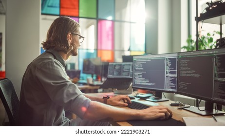 Professional Male Programmer Writing Code on Desktop Computer With Multiple Displays in Stylish Office. Caucasian Man Does Data Scraping For Artificial Intelligence Innovative Start-Up.