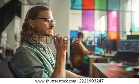 Professional Male Programmer Writing Code on Desktop Computer With Multiple Displays Setup in Stylish Office. Caucasian Man Does Data Scraping For Artificial Intelligence Innovative Start-Up.