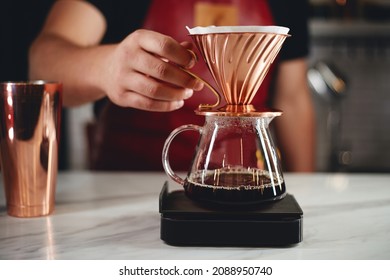 Professional man barista is making drip brewing, filtered coffee, or pour over coffee with hot water and filter paper in coffee shop - Shutterstock ID 2088950740