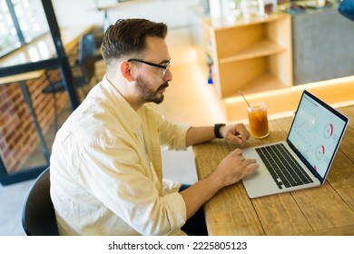 Professional Man Drinking An Iced Coffee And Doing A Work Report Presentation On The Laptop At The Coffee Shop