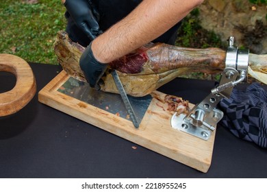 Professional Man Hands Chef With Gloves Black Slicing Iberico Spanish Ham Red In Restaurant Event Party Table