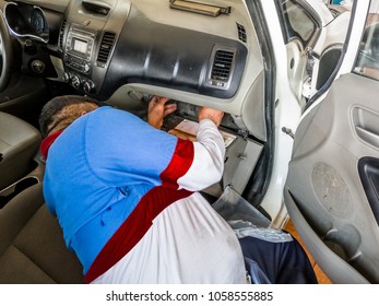 A Professional Man Is Replacing Or Changing The Ac Air Filter Of A Modern Vehicle And Wearing Blue And White Uniform And Laying Down In The Car 