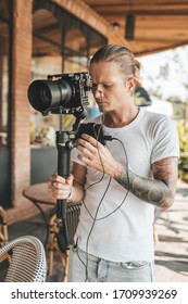 Professional man videographer with stabilizer gimball video slr