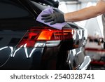 Professional man washes car and wipes with microfiber. Detailing and car wash