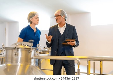 Professional man and woman winemaker inspecting red wine in stainless steel barrel at wine cellar in wine factory. Winery, brewery manufacturing industry factory and winemaking fermentation process. - Powered by Shutterstock