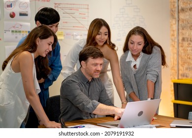 Professional Manger Point To Monitor Of Laptop And Explain The Process Of Work With Project To His Team In Meeting Room Of Office.