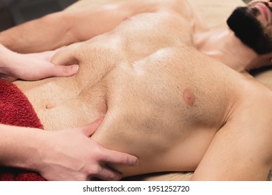 Professional Massage Of The Abdomen For A Man To An Athlete In A Dark Spa Room. Removal Of Adhesions Healthy Intestines