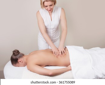 Professional Massage On A Muscle Group (erector Spinae Muscles) Of A Woman's Back 