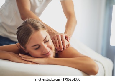 Professional masseur doing therapeutic massage. Woman enjoying massage in her home. Young woman getting relaxing body massage. - Shutterstock ID 1936254370