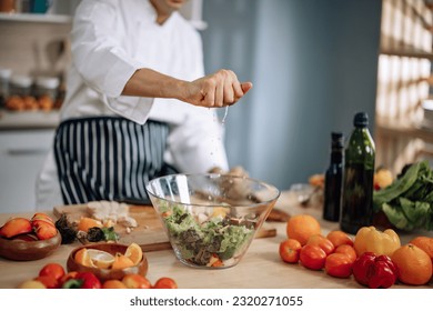 The professional master chef prepares a bowl of various types of fruit and vegetable salad with great passion and enthusiasm. Expertly mix all the ingredients and materials with care and precision. - Powered by Shutterstock