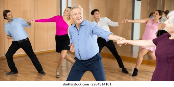 Professional mature male dancer rehearsing ballroom dances in dance studio - Powered by Shutterstock