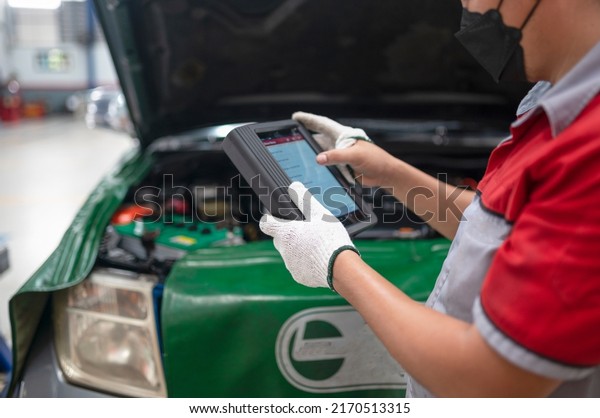 Professional mechanic and check car engine with\
computer diagnostic software.Expertise mechanic working in\
automobile repair\
garage.