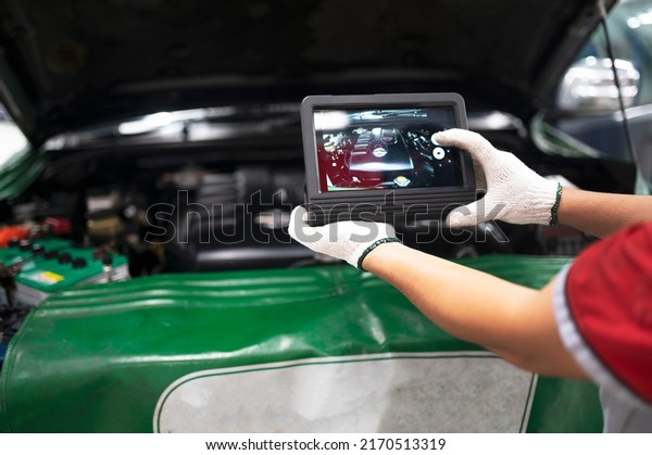 Professional mechanic and check car engine with\
computer diagnostic software.Expertise mechanic working in\
automobile repair\
garage.