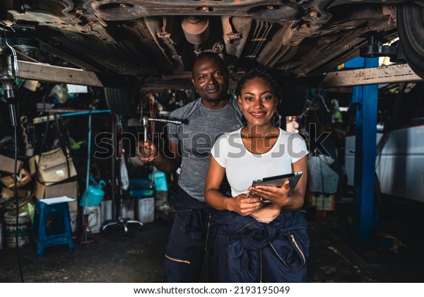 Professional mechanic checking\
the neatness of the car suspension before delivery in the\
garage.
