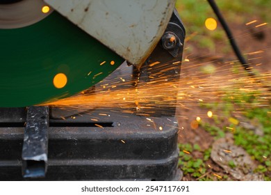 Professional mechanic is cutting steel metal with rotating diamond blade cutter. Steel industry and workshop concept. - Powered by Shutterstock