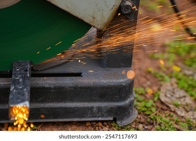 Professional mechanic is cutting steel metal with rotating diamond blade cutter. Steel industry and workshop concept. - Powered by Shutterstock