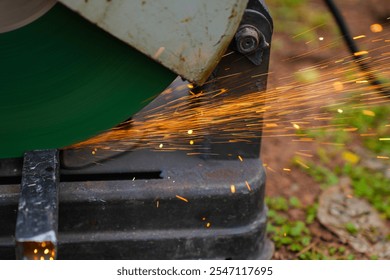 Professional mechanic is cutting steel metal with rotating diamond blade cutter. Steel industry and workshop concept. - Powered by Shutterstock