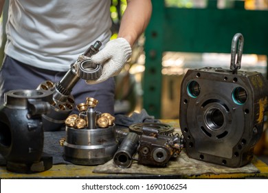 Professional Mechanic Man Holding Bearing Of The Hydraulic Piston Pump To Inspection And Repair Maintenance Heavy Machinery 