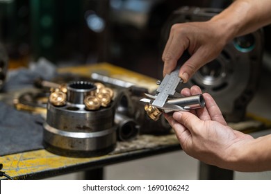 Professional Mechanic Man Holding Piston Of The Hydraulic Pump To Inspection And Repair Maintenance Heavy Machinery 