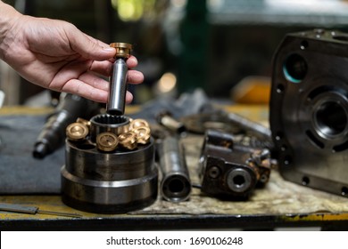 Professional Mechanic Man Holding Piston Of The Hydraulic Pump To Inspection And Repair Maintenance Heavy Machinery 