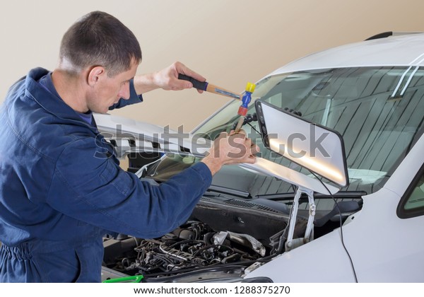 Professional\
mechanic removes dents on the car\
body
