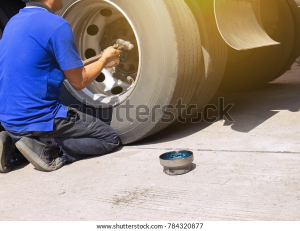 Professional mechanic\
repairing a wheel\
truck