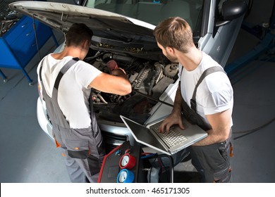 Professional Mechanic Team Repair Car In Workstation