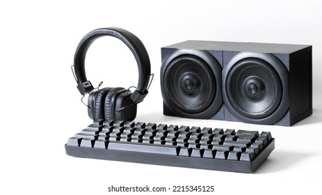 Professional Mechanical Computer Keyboard, Black Wireless Headphones And Two Audio Speakers On A White Background. Recording Audio Studio And Digital Audio Broadcasting. Selective Focus. Close-up