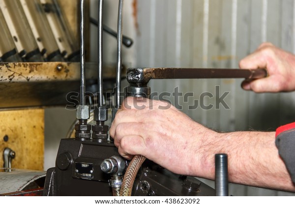 Professional mechanics\
testing diesel injector in his workshop, repair and diagnostics\
equipment, soft\
focus