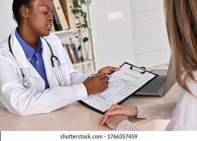 Professional medic female african american doctor showing insurance claim form consult caucasian woman explain information to patient at appointment medical visit in clinic. Medicine women healthcare - Shutterstock ID 1766357459