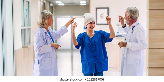 Professional Medical Doctor Team With Stethoscope In Uniform Discussing And Dancing With Happy Patient Woman With Cancer Cover Head With Headscarf Of Chemotherapy Cancer In Hospital.health Care 