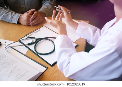 Professional Medical Doctor In White Uniform Gown Coat Interview Consulting Patient.